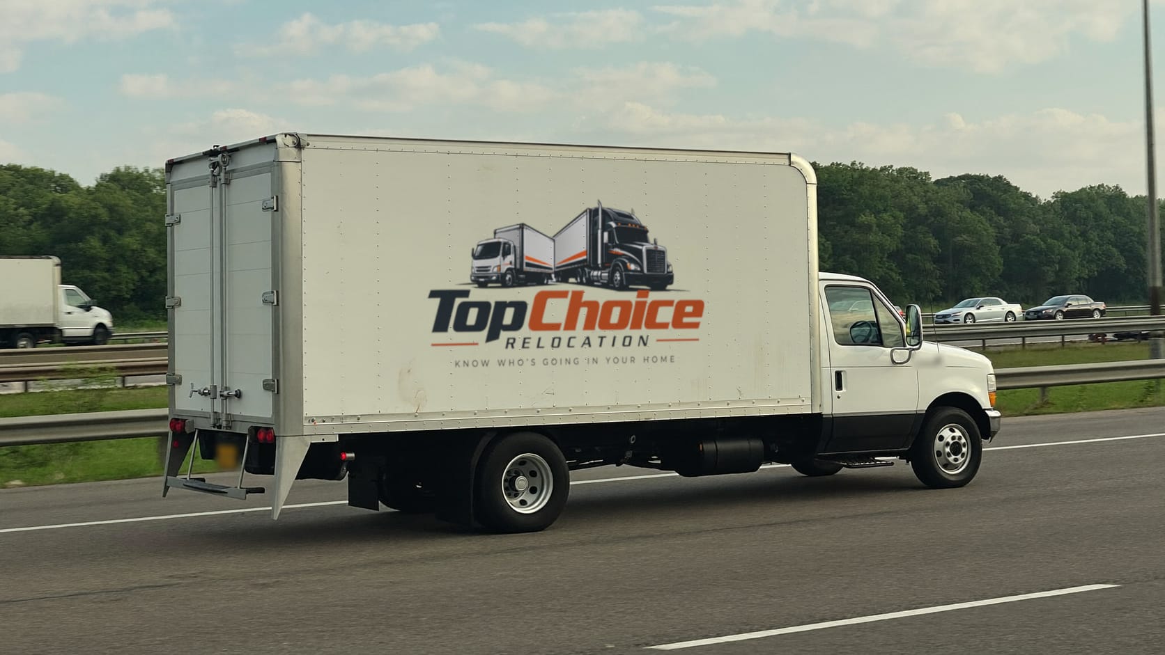 A white box truck with the Top Choice Relocation logo on its side, driving on a highway